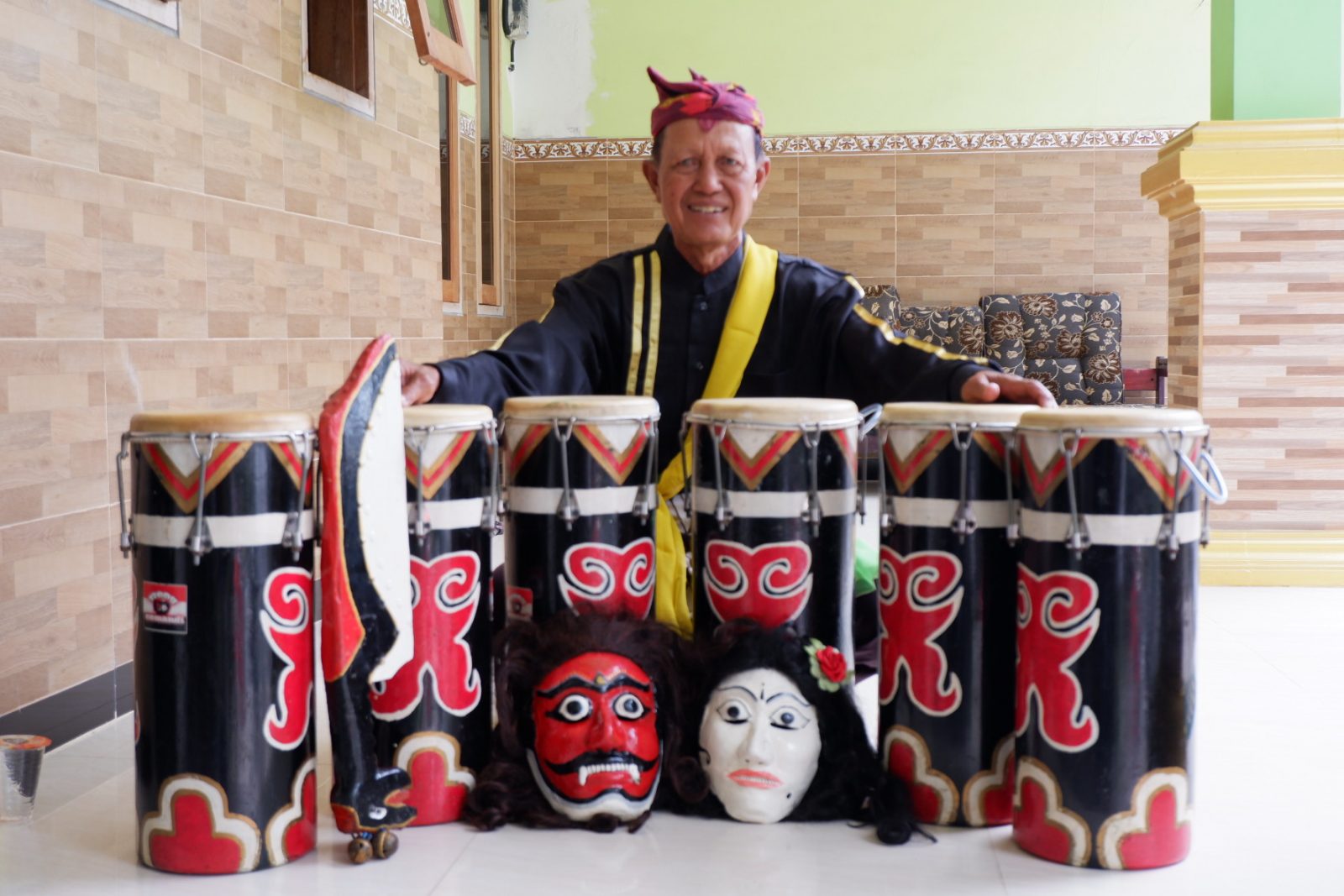 JIWA SENI: Susilo menunjukkan peralatan yang dipakai saat Reog Cemandi ditampilkan. Terdiri dari gendang, angklung, dua topeng dan senjata yang terbuat dari kayu. (RIZKY PUTRI PRATIMI/RADAR SIDOARJO)