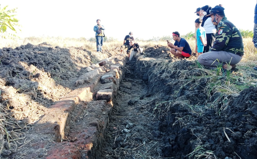 MISTERIUS: Sebuah struktur batu bata yang menyerupai bangunan pagar terpendam di dalam area persawahan. (LUKMAN AL FARISI/RADAR SIDOARJO)