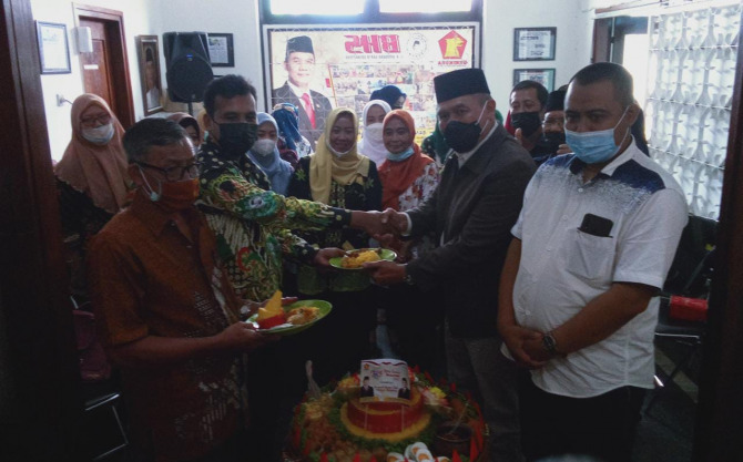 HORMATI GURU: Bambang Haryo Soekartono (dua dari kanan) menyerahkan potongan tumpeng kepada perwakilan guru.