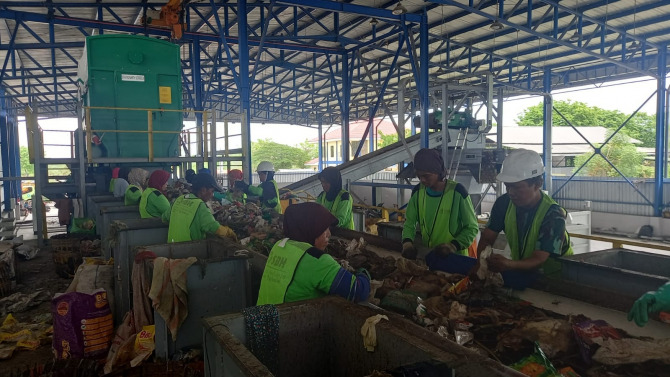 ATASI PENUMPUKAN: DLHK mulai menjalankan mesin shorting. Pemilihan dibantu 20 orang pemulung. (RIZKY PUTRI PRATIMI/RADAR SIDOARJO)