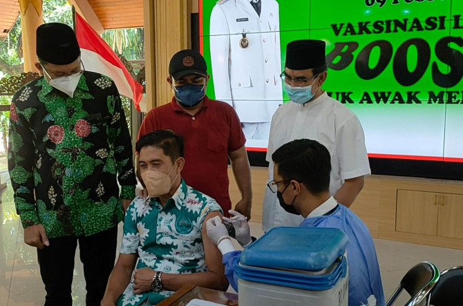 BIAR SEHAT: Ketua PWI Sidoarjo Abdul Rouf saat disuntik vaksin booster didampingi Bupati Sidoarjo Ahmad Muhdlor (kiri).