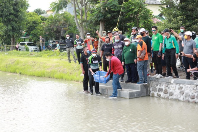 BISA MANCING: Bupati Sidoarjo Ahmad Muhdlor melepaskan ikan nila merah di bozem kawasan Perumahan Sekardangan Indah (SKI).