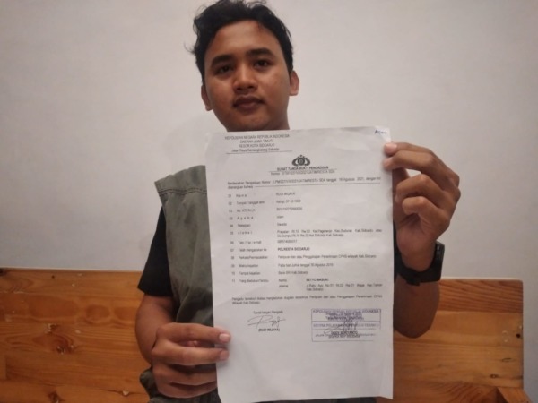 DITIPU: RW menunjukkan laporan polisi terkait kasus penipuan yang menimpanya. (HENDRIK MUCHLISON/RADAR SIDOARJO)