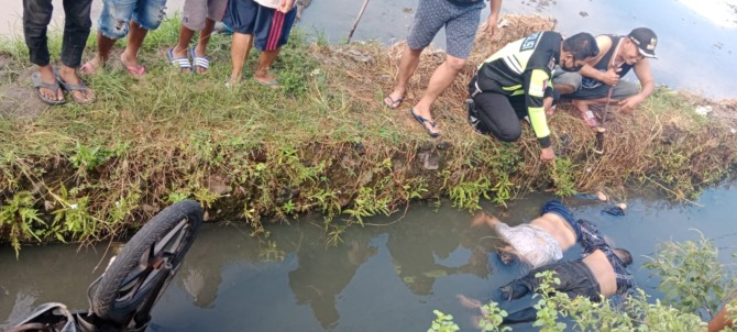 PENYELIDIKAN: Kondisi dua korban dan motornya di saluran irigasi Desa Balongdowo.