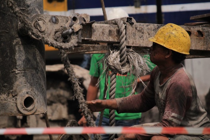 PEMBERDAYAAN: Pekerja sedang memasang sheet pile dalam proyek frontage road. (HENDRIK MUCHLISON/RADAR SIDOARJO)