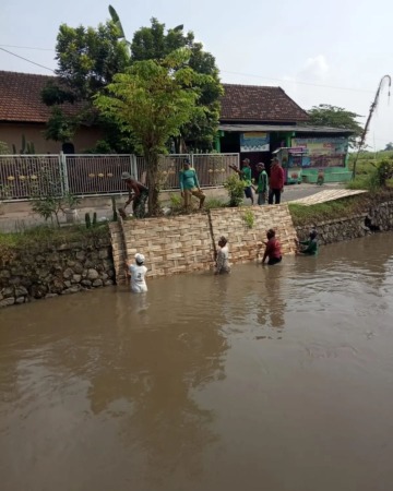 SOLUSI AWAL: Pemasangan bambu dilakukan di plengsengan Sungai Desa Mojoruntut.