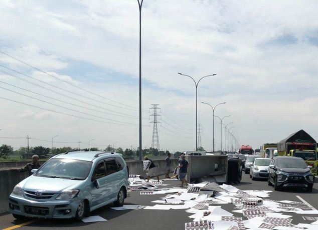 MACET: Muatan pikap yang terguling berhamburan di Jalan Tol Porong arah Kejapanan.