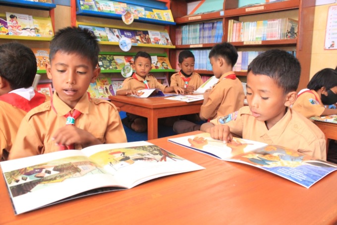 CERIA: Siswa SDN Ketegan Tanggulangin sedang asyik membaca dan melihat gambar di buku perpustakaan ramah anak. (HENDRIK MUCHLISON/RADAR SIDOARJO)