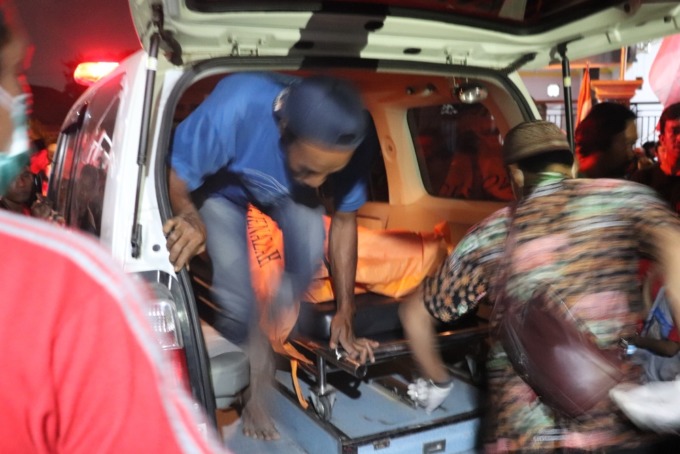 MENGEJUTKAN: Jenazah korban saat dievakuasi anggota polisi. (LUKMAN AL FARISI/RADAR SIDOARJO)