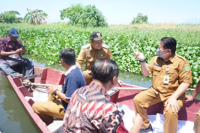 LIHAT LOKASI: Wakil Bupati Sidoarjo Subandi saat sidak di Sungai Buntung menggunakan perahu.
