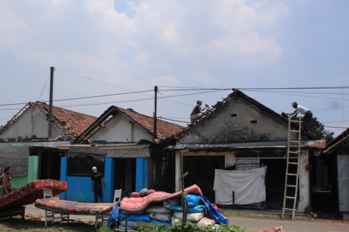 CUACA EKSTREM: Warga Desa Durung Bedug, Kecamatan Candi saat memperbaiki atap rumahnya yang rusak tersapu angin. (HENDRIK MUCHLISON/RADAR SIDOARJO)