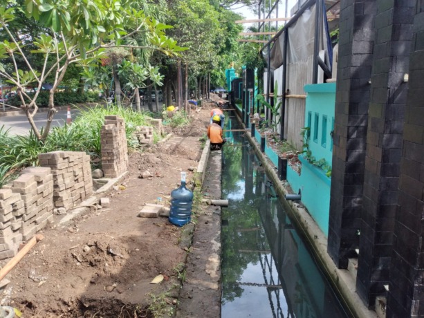 LANCAR : Pekerja sedang memperbaiki gorong-gorong di depan SMAN 2 Sidoarjo. (HENDRIK MUCHLISON/RADAR SIDOARJO)