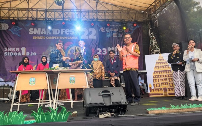 SEMARAK: Kepala SMK Negeri 1 Sidoarjo, Dhanu Lukmantoro menyerahkan potongan tumpeng kepada Ketua OSIS saat pembukaan Smakid Fest 2022.