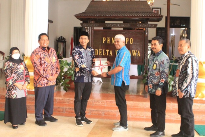 DITUNTASKAN: Kepala BPN Sidoarjo Yannis Harryzon Dethan (tiga dari kanan) menyerahkan sertifikat aset Pemkab kepada Bupati Sidoarjo Ahmad Muhdlor. (HENDRIK MUCHLISON/RADAR SIDOARJO)