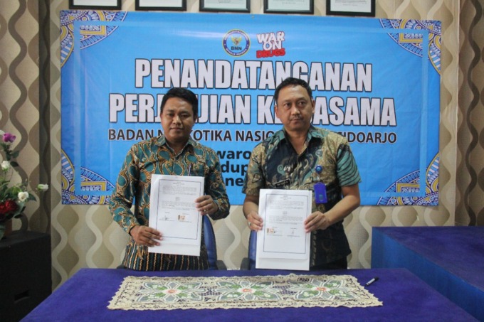 DITEKEN: Kepala SMP Kemala Bhayangkari 7 Porong, Kafi Muslihuddin, S.Pd, Gr. (kiri) saat menunjukkan surat perjanjian kerja sama bersama Kepala BNNK Sidoarjo, Kombes Pol. R.M. Tohir H., S.I.K. (IST)