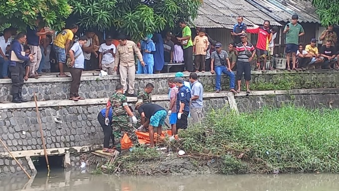 MENINGGAL: Proses evakuasi mayat yang disaksikan warga sekitar.