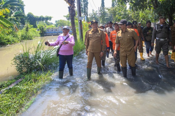 MENINJAU: Wabup Subandi saat menyidak banjir di dua desa di Kecamatan Candi.
