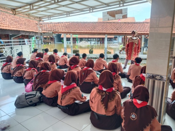TETAP SEMANGAT: Sejumlah siswa SMPN 2 Tanggulangin saat belajar di teras masjid sekolah saat kelas kebanjiran. (IST)