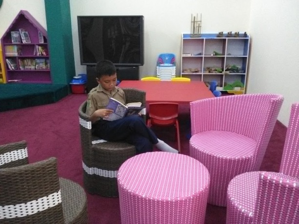 MINAT BACA: Salah satu siswa sedang memanfaatkan sudut baca di perpustakaan Sidoarjo. (IST)