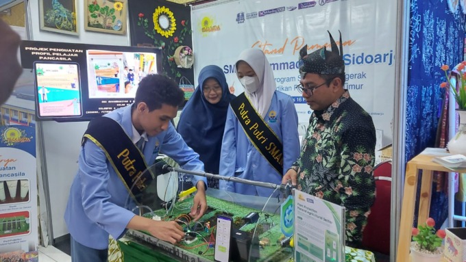 INOVATIF: Kepala Sekolah SMA Muhammadiyah 2 Sidoarjo M Zainul Arifin, S.Kom., M.M. meliaht karya siswanya di Projects Management Office. (VEGA DWI ARISTA/RADAR SIDOARJO)
