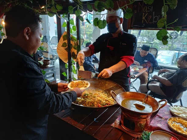 NIKMAT: Salah seorang pengunjung yang menikmati nasi kebuli khas Timur Tengah. (ZAINUL FAJAR/RADAR SIDOARJO)