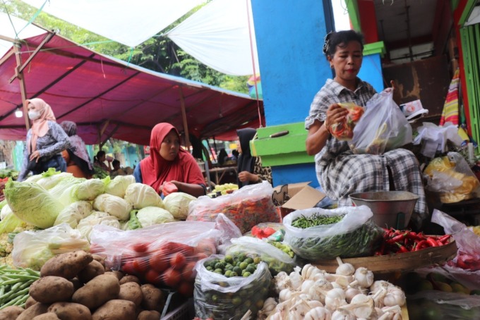 MELONJAK: Salah satu pedagang Pasar Larangan, Sukarni, saat melayani pembeli. (LUKMAN AL FARISI/RADAR SIDOARJO)