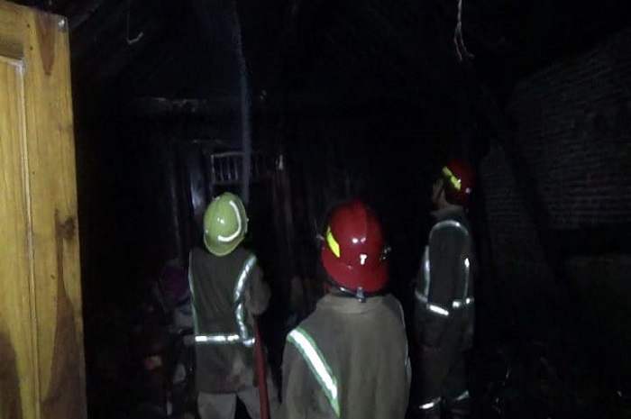 Petugas Pemadam Kebakaran dari Pos Damkar Mojoagung saat melakukan pembasahan di rumah yang terbakar di Desa Grobogan, Kecamatan Mojowarno