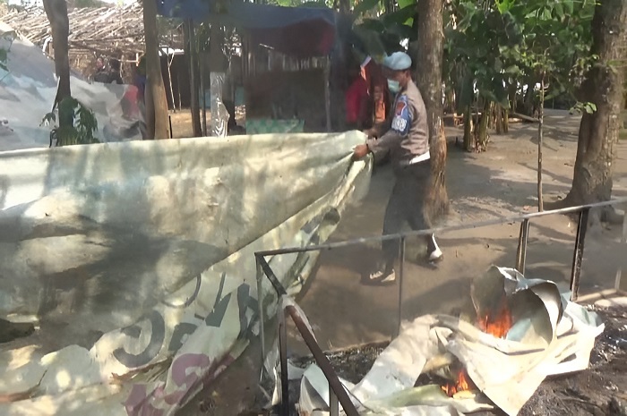 Petugas kepolisian dari Polsek Sumobito saat melakukan pembongkaran bekas arena judi sabung ayam di Desa Bakalan, Kecamatan Sumobito, Kabupaten Jombang