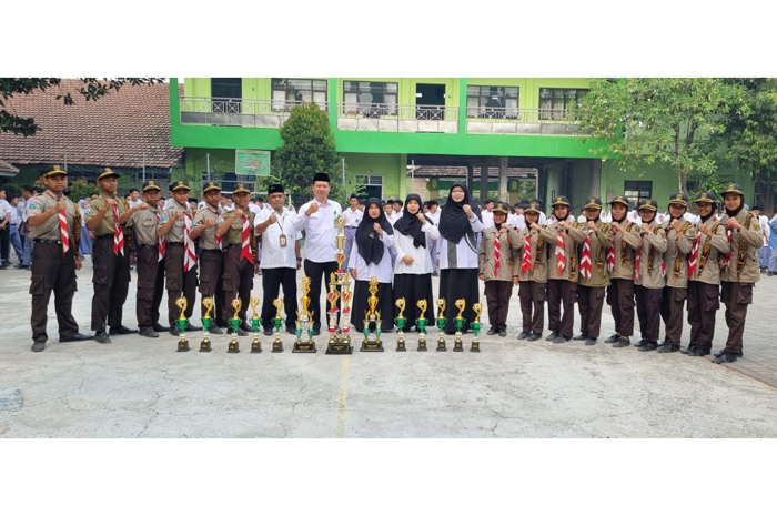 Kepala MAN 6 Jombang Masrukhin SAg MPdI menyerahkan piala kepada juara umum lomba Pramuka Kobbar 2023.