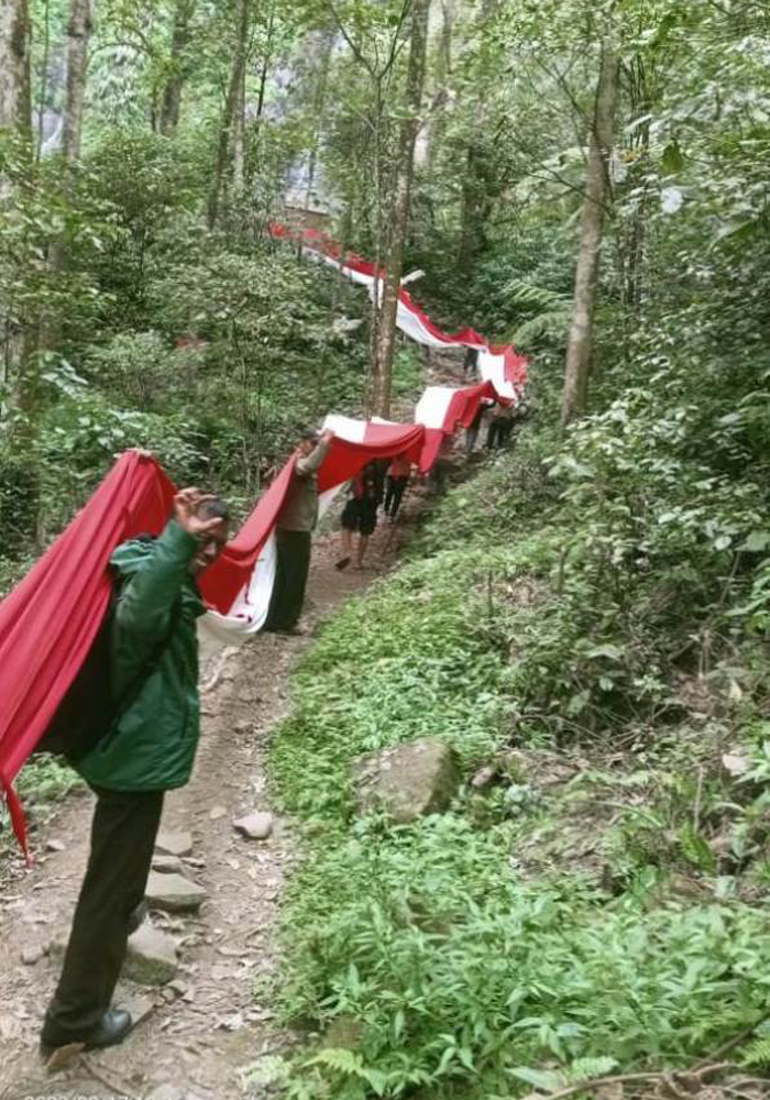 Puluhan pecinta alam saat mengibarkan bendera merah putih di kawasan wisata air Terjun Tretes Wonosalam kemarin.