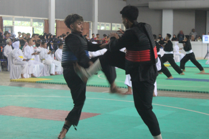 Pesilat Jombang Fandicha Tegar (biru) bertanding melawan Yoga Aldi dari Bojonegoro pada kelas C, di Auditorium Undar  Jombang, kemarin (21/8).