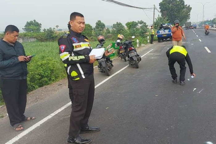 Petugas kepolisian saat melakukan olah kejadian perkara di lokasi kejadian kecelakaan maut di Mojoagung