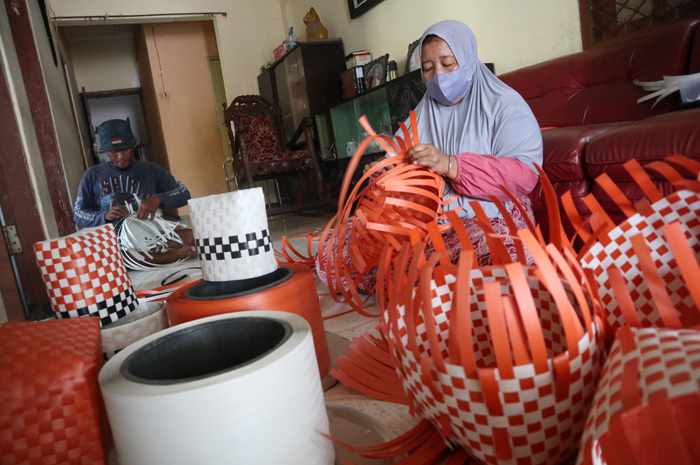 Pasangan suami istri Indah Wahyuni, 42, dan Handoko, 43, warga Dusun Parimono, Desa Plandi, Kecamatan Jombang membuat tas anyaman plastik di rumahnya.