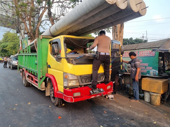 Kondisi truk yang kacanya pecah dan keneknya tewas tergencet muatan tiang listrik dari truk di depannya