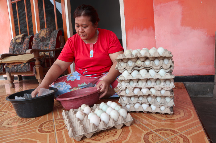 Indi Wahyuni, 41, tengah memproduksi telur asin di rumahnya, di Desa Rejosopinggir, Kecamatan Tembelang, Jombang