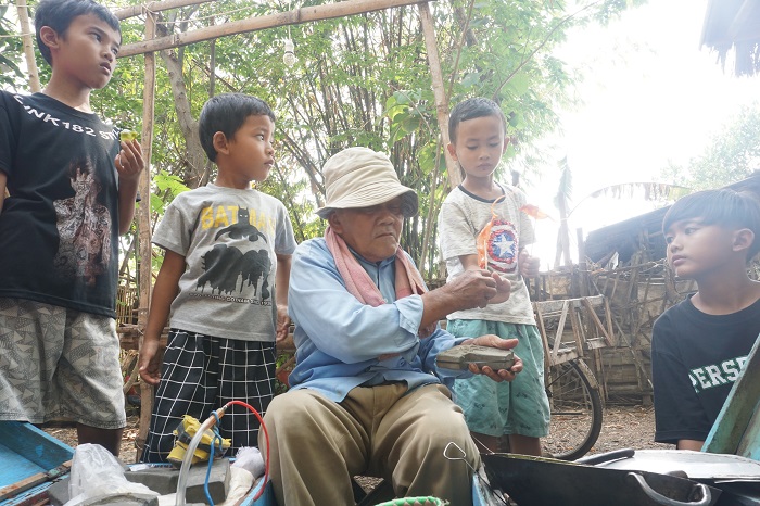 Ateng, 87 penjual jajan gulali saat menjajakan dagangannya di Desa Grogolan
