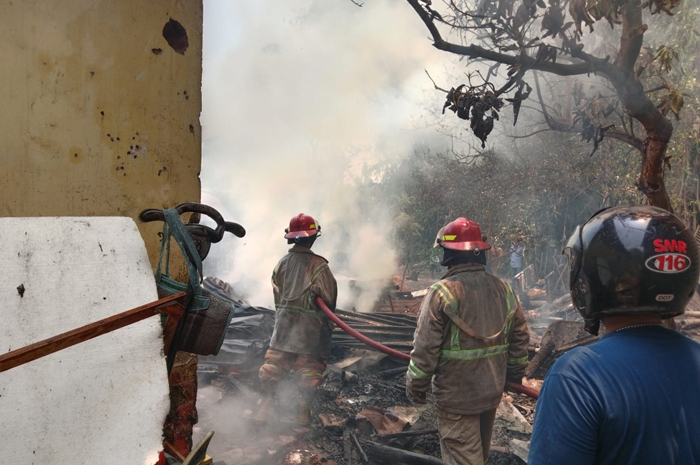 Petugas pemadam kebakaran saat memadamkan api yang melahap rumah seorang lansia di Desa Pandanwangi, Diwek, Jombang yang ludes terbakar