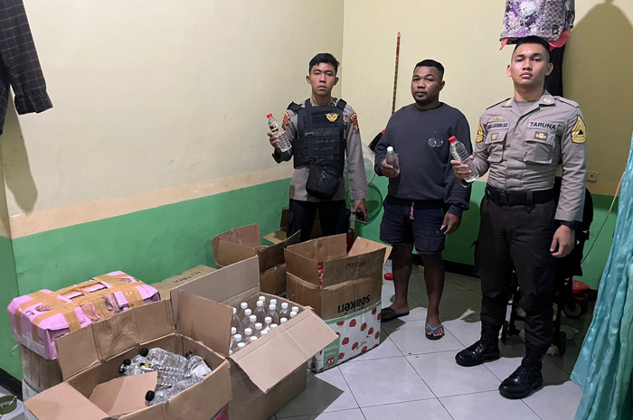 Polisi saat menyita ratusan botol miras jenis arak bali dari tersangka. Miras ini, biasanya diedarkan disuplai ke sejumlah warkop dan angkringan di Jombang