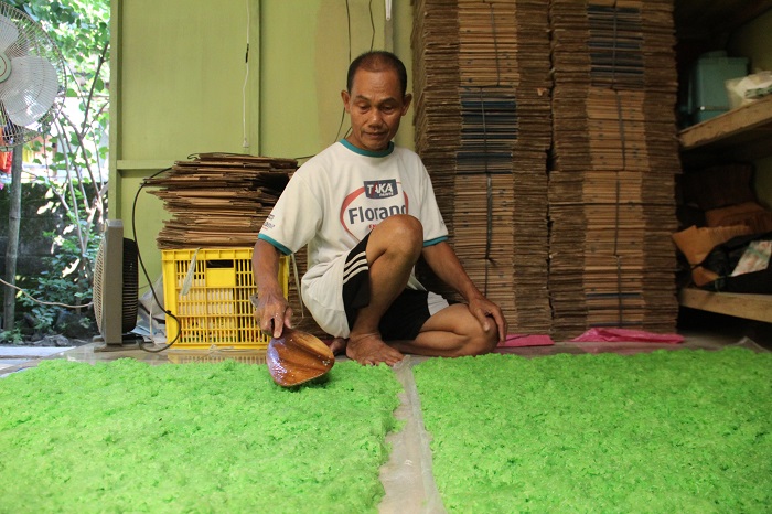 Warga Dusun/Desa Kedawong, Kecamatan Diwek memproduksi tape ketan hijau di rumahnya, Minggu (5/11).