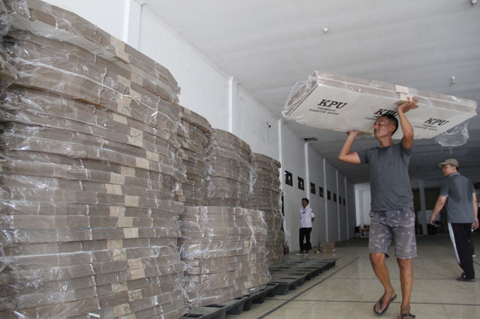 Petugas menurunkan logistik bilik suara di gudang KPU Jombang kemarin (9/11).
