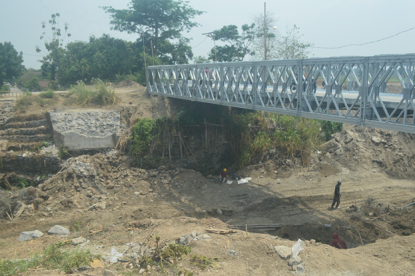 SIsa jembatan melengkung di atas Kali Konto Desa Gondangmanis, Bandarkedungmulyo Jombang yang telah dibongkar. Warga kini bisa menggunakan jembatan bailey meski masih harus bergantian.