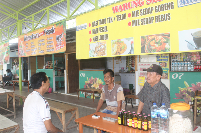 Kepala Desa Candimulyo Sufredo Herlan (bertopi), di pujasera tepi sungai Jombang Wetan.