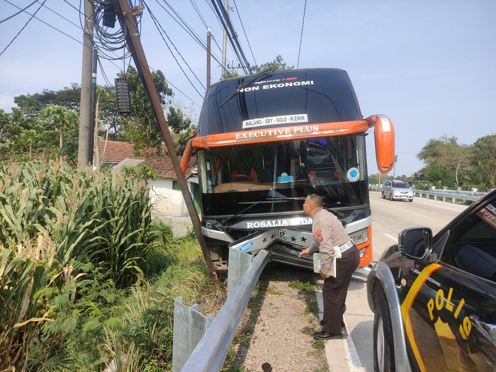 Kondisi bus AKAP yang menancap guardrail usai menyerempet motor roda tiga di jalur arteri nasional Desa Glagahan, Perak, Jombang Minggu (19/11)