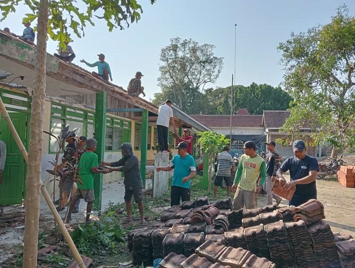KOMPAK: Warga Desa Cupak Kecamatan Ngusikan dan guru MI Raden Patah bersama-sama memperbaiki MI yang ambruk, Minggu (26/11).