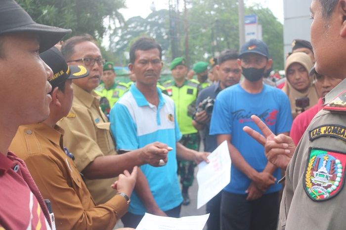 SERIUS: Tim penyelamatan aset daerah melakukan koordinasi sebelum melakukan penyegelan ruko simpang tiga, Jombang, Senin (27/11)