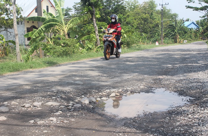 Warga melewati jalan rusak di Dusun Sendangrejo, Desa Banjardowo Kecamatan Jombang.