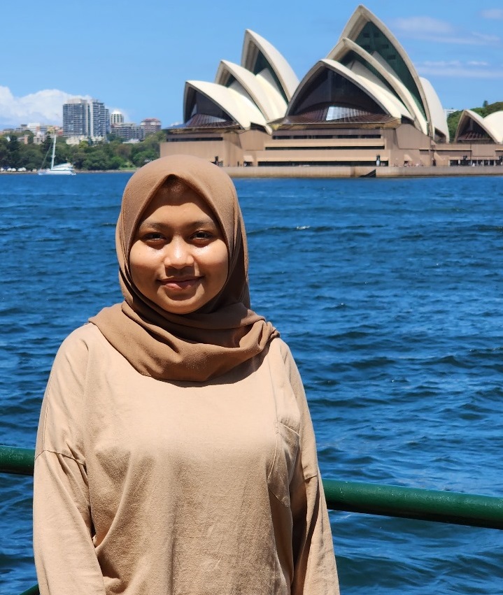 Ari F Dewi sedang berfoto dengan latar belakang opera house di Sydney, Australia