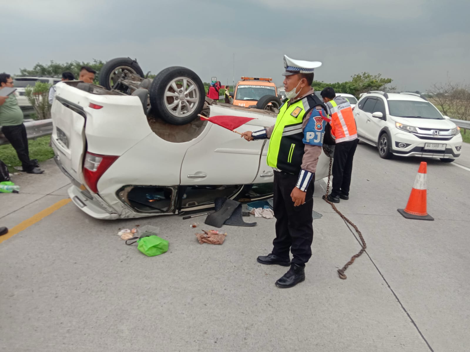 Petugas kepolisian saat melakukan olah TKP kecelakaan Xenia terbalik di Tol Jombang Mojokerto