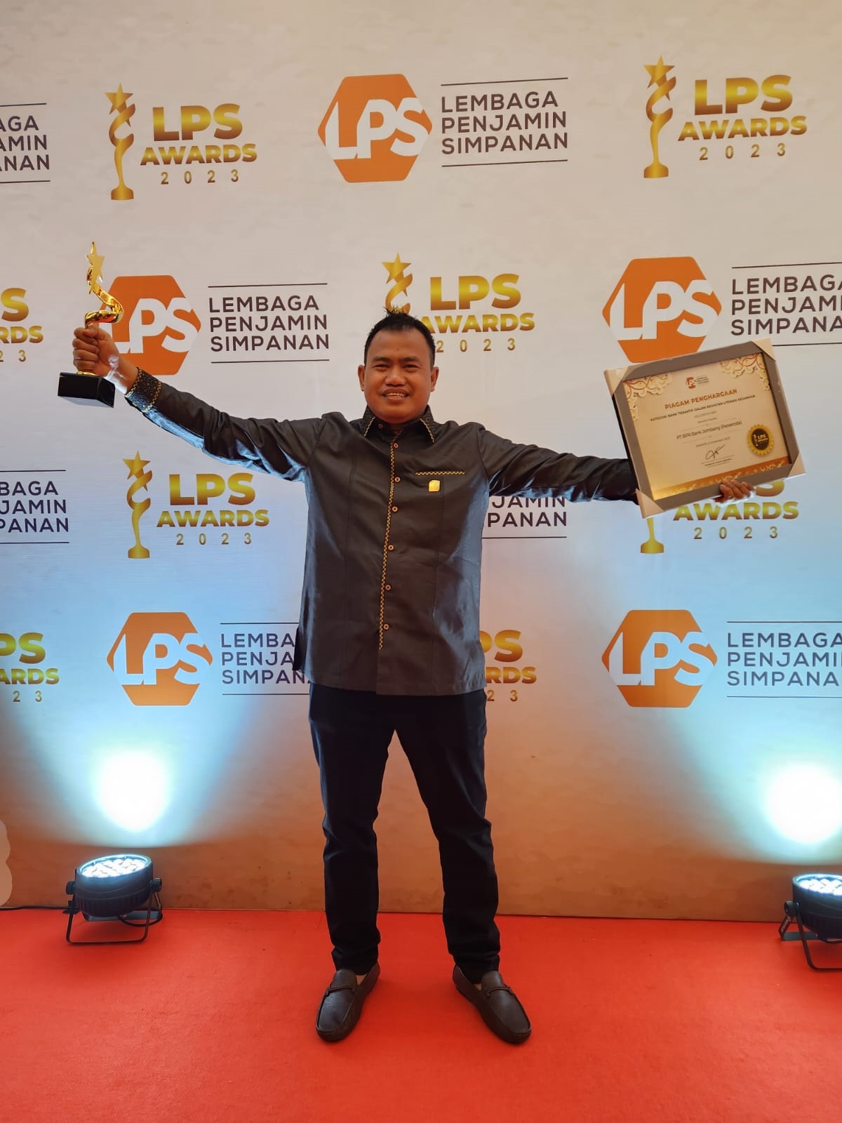 Direktur Utama Bank Jombang, Afandi Haris Setyo Nugroho, menunjukkan trofi dan piagam penghargaan LPS Awards 2023 kategori Bank Teraktif Dalam Kegiatan Literasi Keuangan yang baru saja diterima.