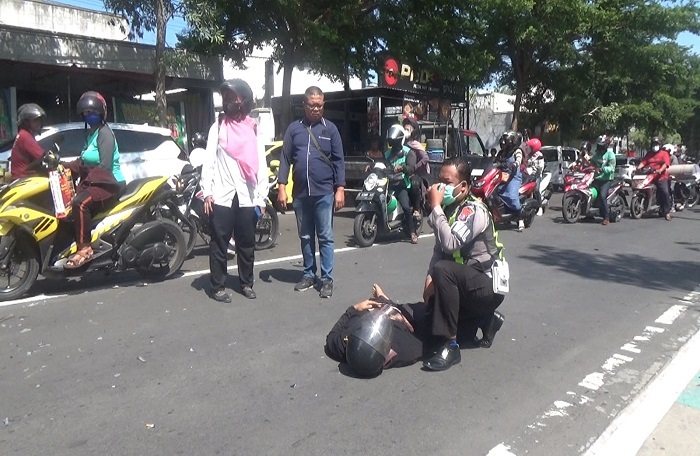 polisi menolong korban laka di Jl KH Wahid Hasyim Senin (11/12).